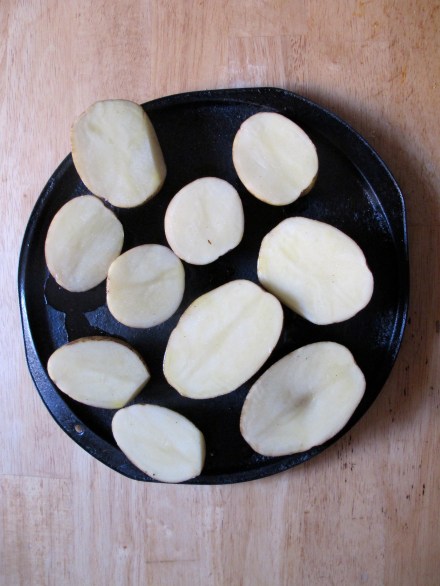 First steps are to wash and slice your russet potatoes in half.  Next, you lather both sides with olive oil.  I recommend pouring some of your best olive oil in a ramekin and letting it sit with minced garlic before applying.  You can sprinkle a bit of salt and put them in the oven as is for half hour (my mother-in-law taught me this quick, basic and flavorful way to bake potatoes).
