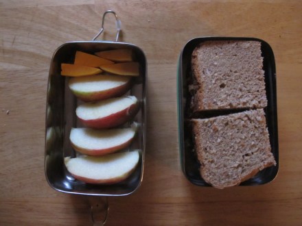 Tahini, banana, honey sandwich with apple slices and cheddar cheese for snacking.