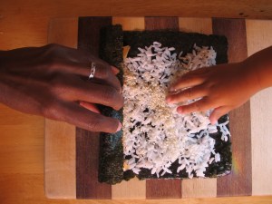 Roll it starting from the side that has the salmon.  Don't let big brother see little brother steal some of his rice