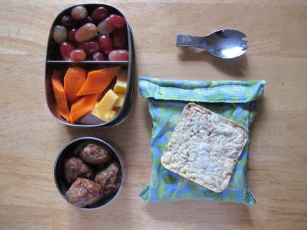 Pineapple Teriyaki Chicken Meatballs (Aidell's), Carrots, Grapes, Cheddar Cheese, and quinoa "rice" cakes in a no waste sandwich bag (Etsy shop Fourth World Living)